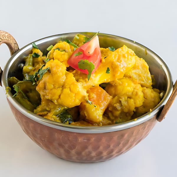 Indian Gobi Aloo, a cauliflower and potato curry, in a copper serving bowl.